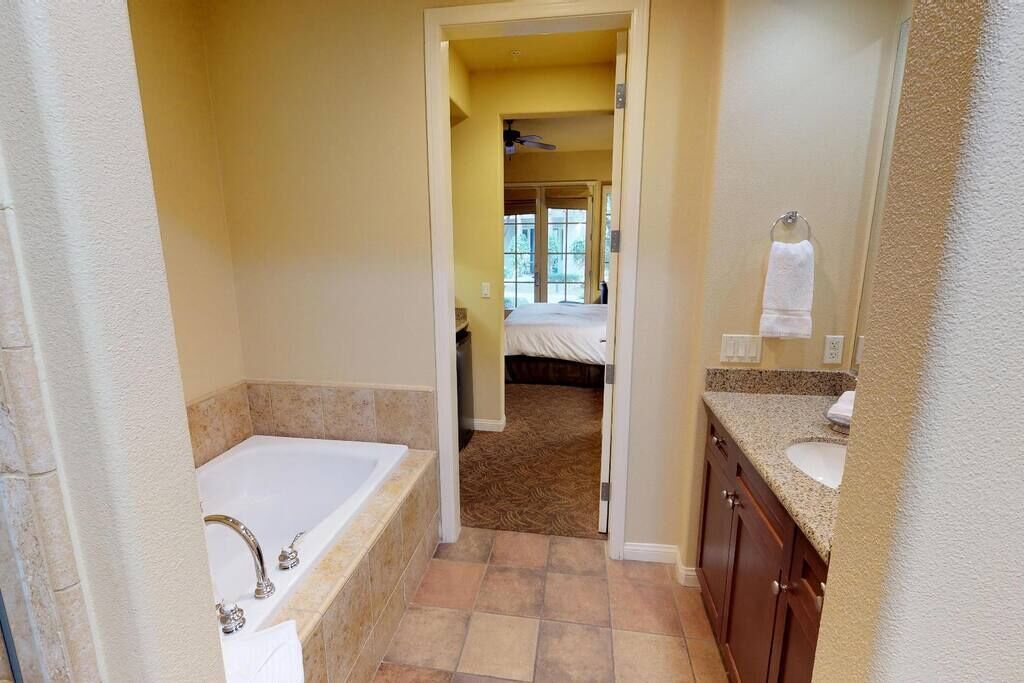 A bathroom with a bathtub, a sink, and a shower area.