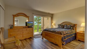 Une chambre à coucher avec un lit en bois, une commode, une chaise et un grand miroir.