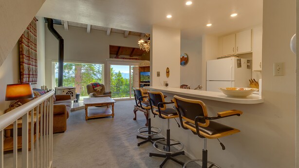 Une cuisine moderne avec un coin bar, des meubles en bois et une vue sur l’extérieur.