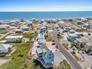 Uma área residencial costeira com casas, uma estrada e uma praia.