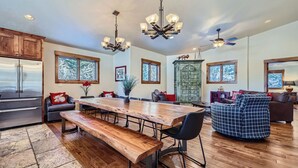 A spacious living area with a large wooden dining table, comfortable seating, and a decorative metal gate. - Free SkyCard - Spacious Luxury Home, Private Hot Tub, Theater - Casa de Plata (Breckenridge)