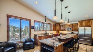 A spacious kitchen with a large island, wooden cabinets, and a stainless steel refrigerator. - Free SkyCard - Spacious Luxury Home, Private Hot Tub, Theater - Casa de Plata (Breckenridge)