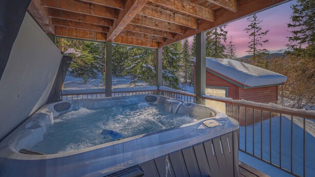 A hot tub on a wooden deck with a view of snowy trees and a house in the background. - Free SkyCard - Spacious Luxury Home, Private Hot Tub, Theater - Casa de Plata (Breckenridge)