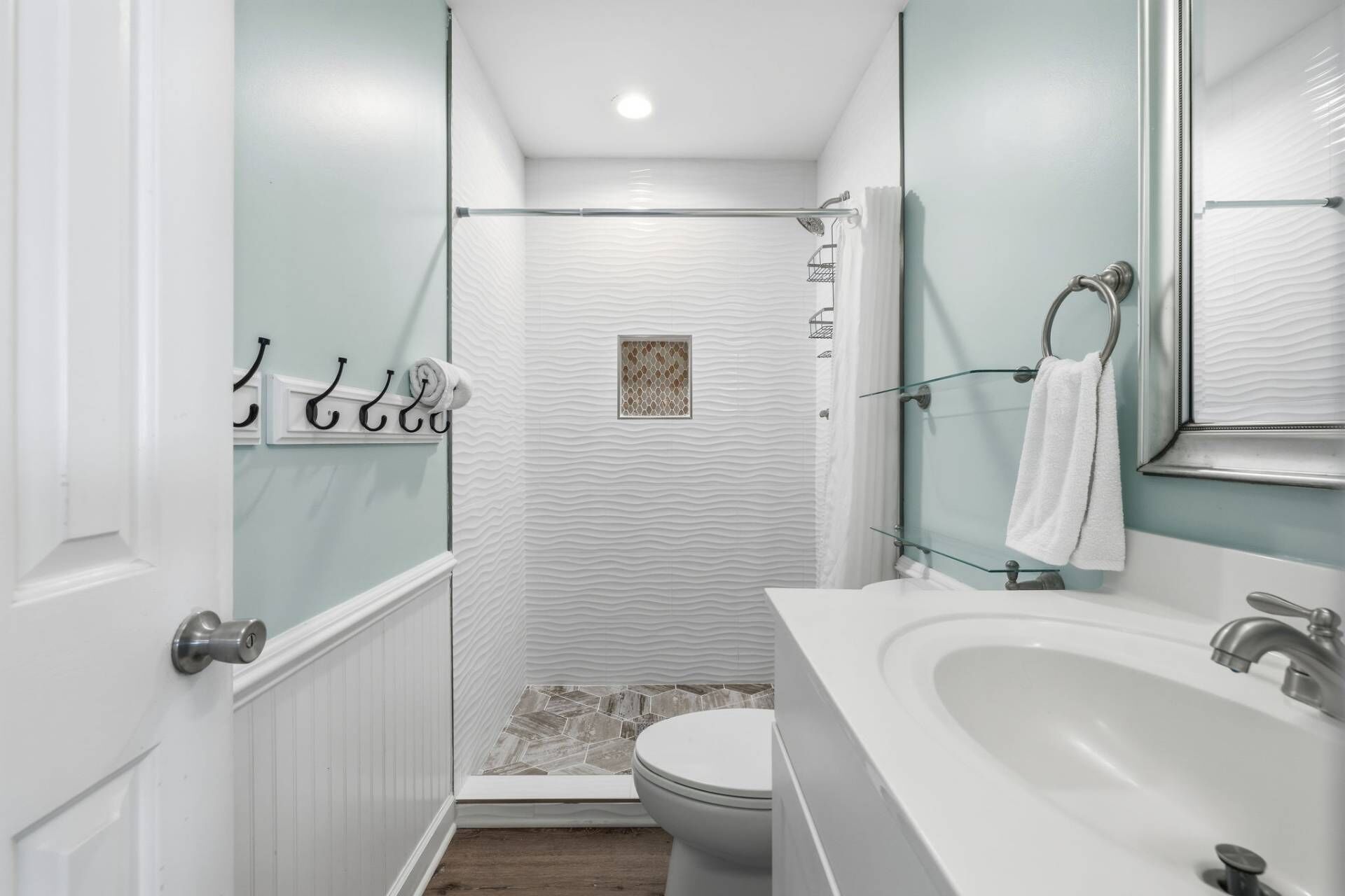 A bathroom with a shower, toilet, and sink.