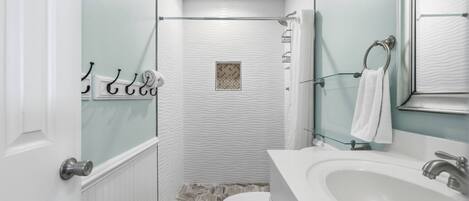 A bathroom with a shower, toilet, and sink.
