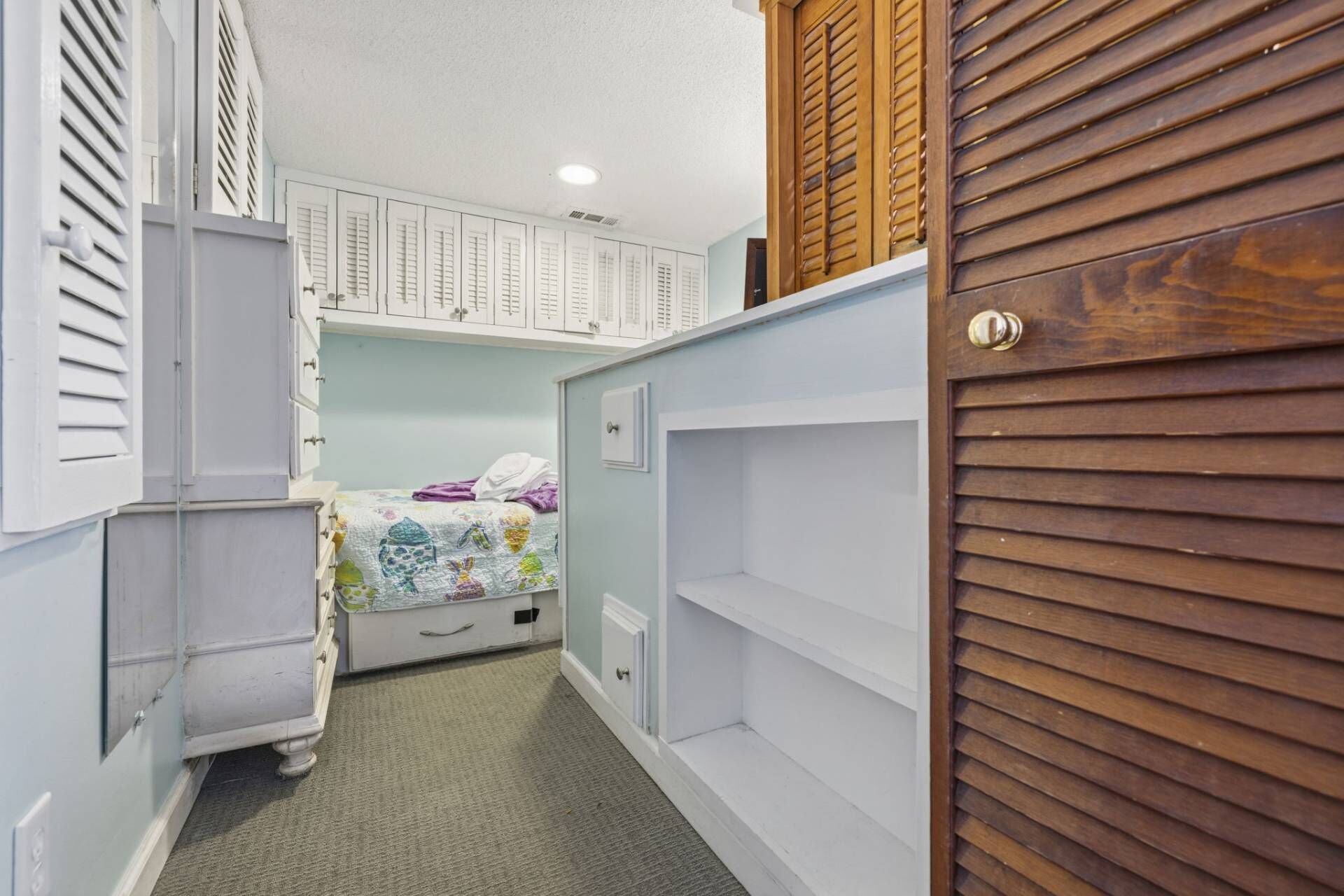 Ein Schlafzimmer mit Etagenbett, Kommode und Kleiderschrank.