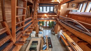 A spacious loft-style room with a high ceiling, wooden beams, and a mezzanine level. - Classic Oceanfront Stinson - The Whale House (Stinson Beach)