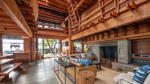 A spacious living area with a wooden ceiling, a sofa, a coffee table, and a fireplace. - Classic Oceanfront Stinson - The Whale House (Stinson Beach)