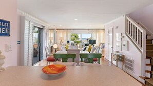A spacious living area with a dining table, chairs, and a view of the outdoors. - Relaxing Tybee Home Overlooking the Ocean (Tybee Island)