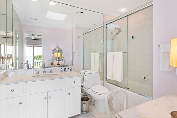 Une salle de bain moderne avec une douche à parois de verre, un lavabo blanc et des toilettes.
