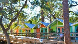 A row of colorful cabins with a wooden deck in front. - Relaxing Tybee Home Overlooking the Ocean (Tybee Island)