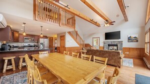 A spacious kitchen with wooden cabinets, a large island, and a dining area with a wooden table and chairs.