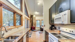Eine moderne Küche mit Granit Arbeitsplatten, einem eingebauten Herd und einem Kamin aus Stein.
