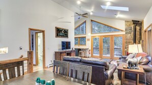 Ein geräumiges Wohnzimmer mit einem großen Holzesstisch, Ledersofas und einem Steinkamin.
