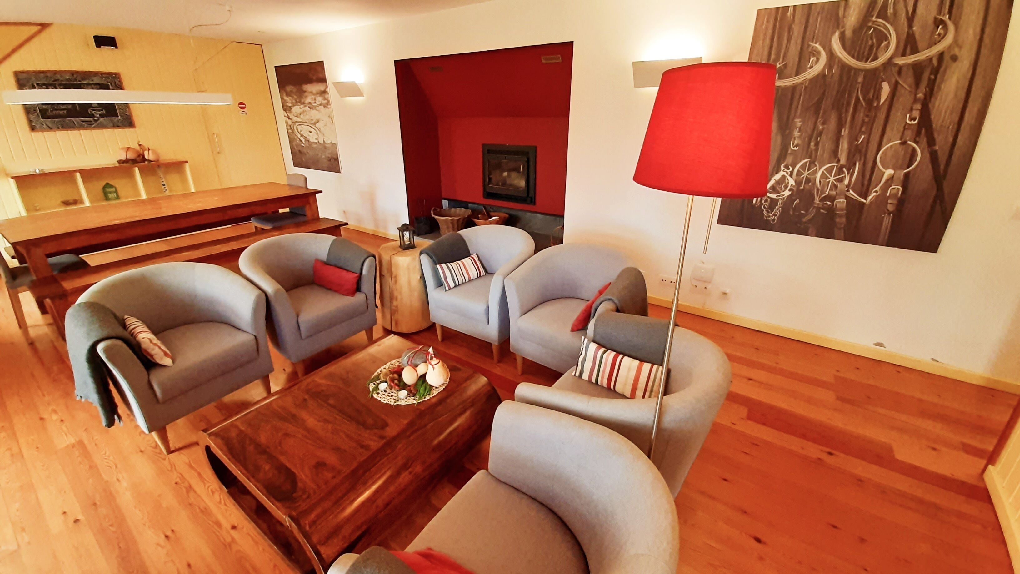 A modern living room with grey armchairs, a wooden coffee table, and a red floor lamp.