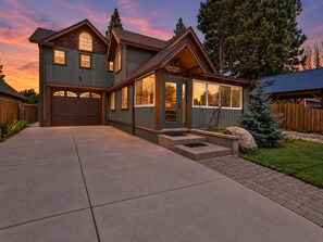 A two-story house with a garage, a front porch, and a well-maintained lawn.