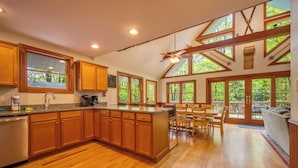 A spacious kitchen with wooden cabinets, a central island, and large windows. - Arrowhead by PMR, 6 BR Lodge, Sleeps 16, Near Lake & Restaurants, Hot Tub (Lake Harmony)