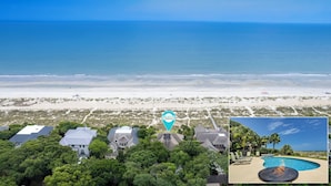An aerial view of a beachfront property with a swimming pool and a fire pit.