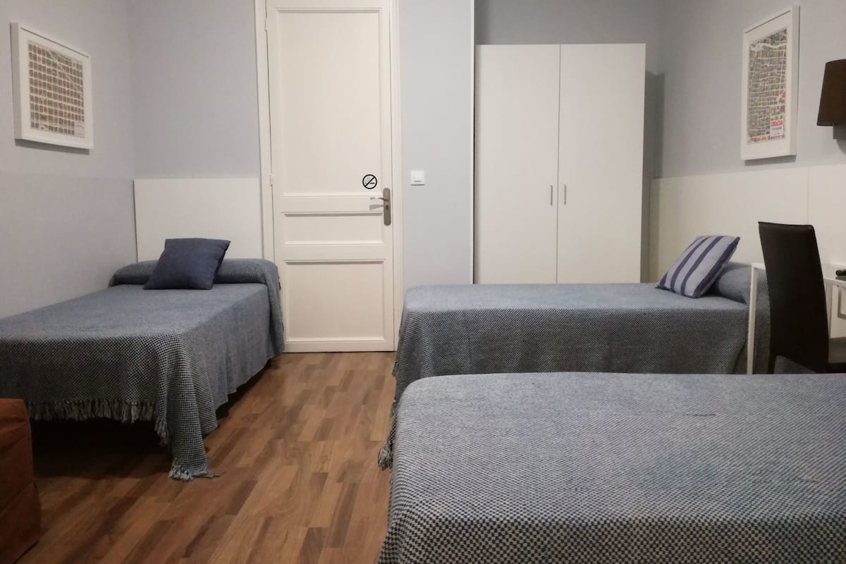 Una habitación con dos camas individuales, un armario y una puerta con cerradura.