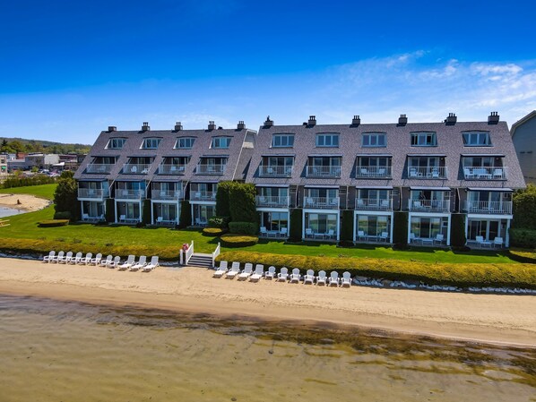 A multi-story hotel with balconies and a beach view.