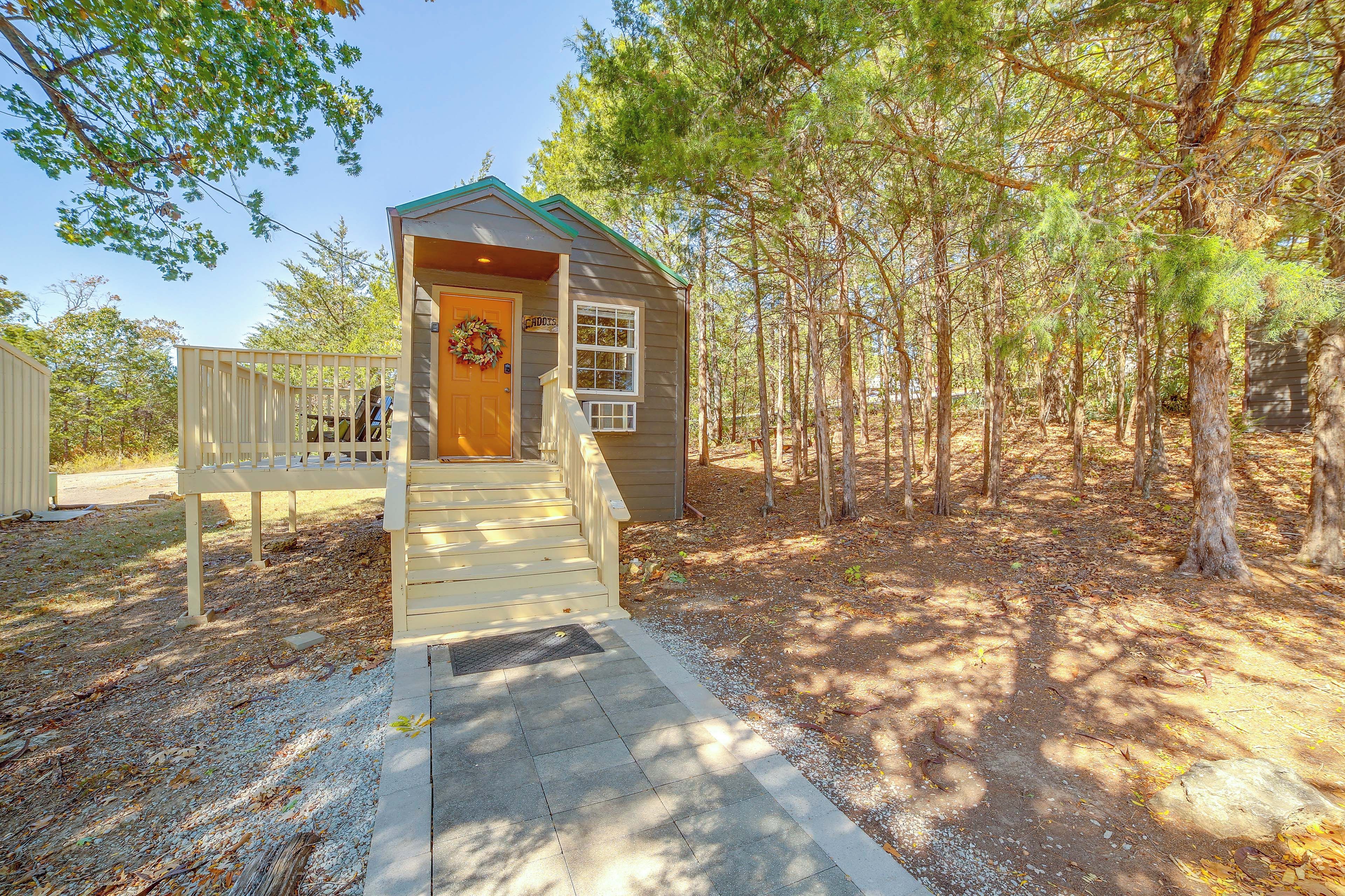 A small wooden cabin with a porch and steps leading to the door.