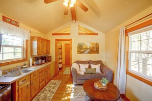 A spacious kitchen with wooden cabinets, a built-in microwave, and a large window.