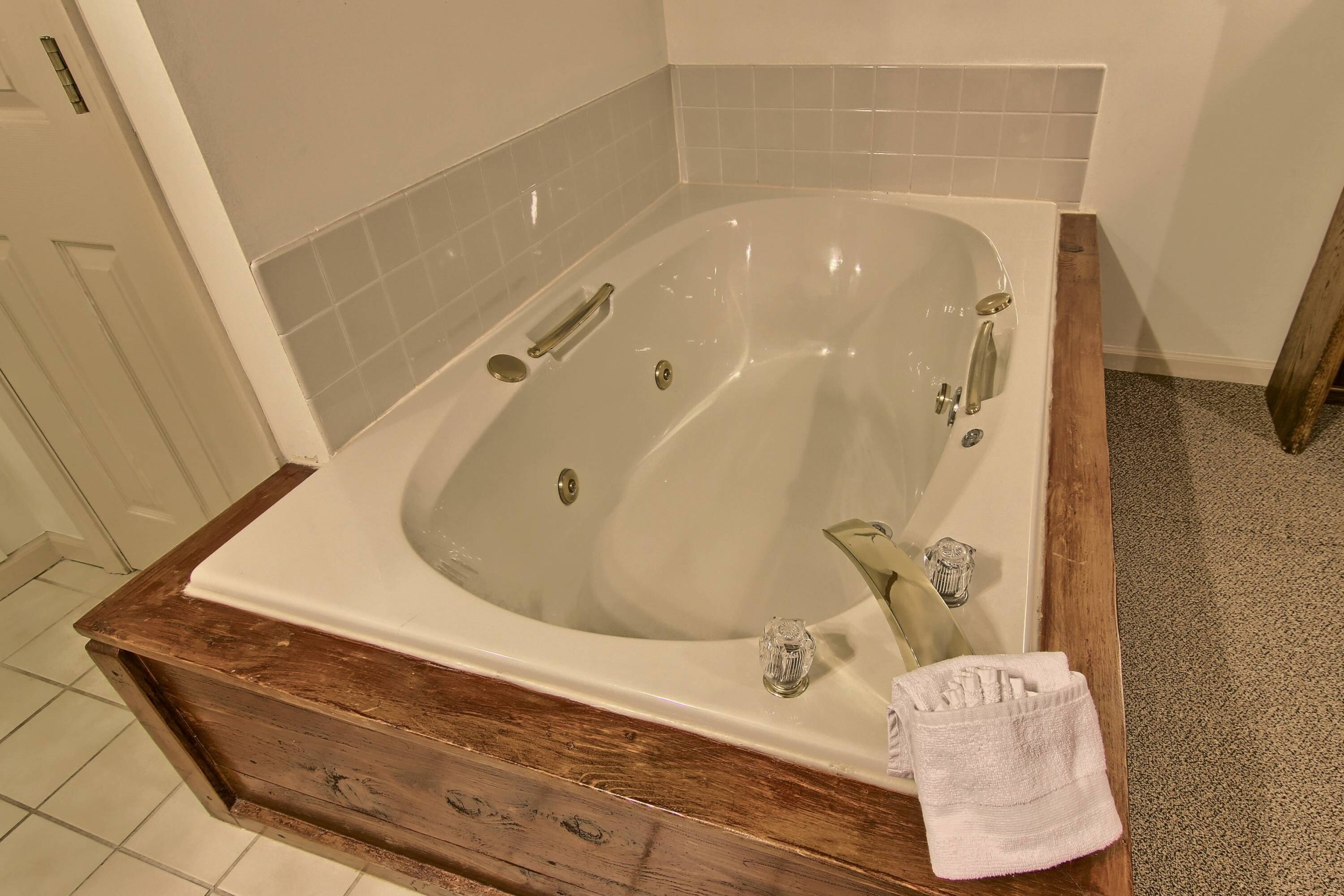 A bathroom with a freestanding bathtub, a wooden vanity, and a glass shower enclosure.
