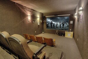 A home theater with a large screen, multiple seating, and a carpeted floor. - Cabin w/views-Indoor Pool-Theater-Game Room (Cosby)