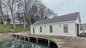 Una casa con un muelle que se extiende sobre el agua, rodeada de árboles.