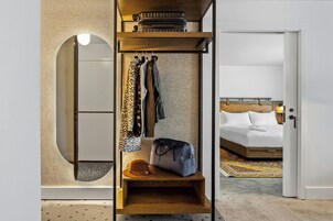 Una habitación de hotel con armario, cama y espejo.