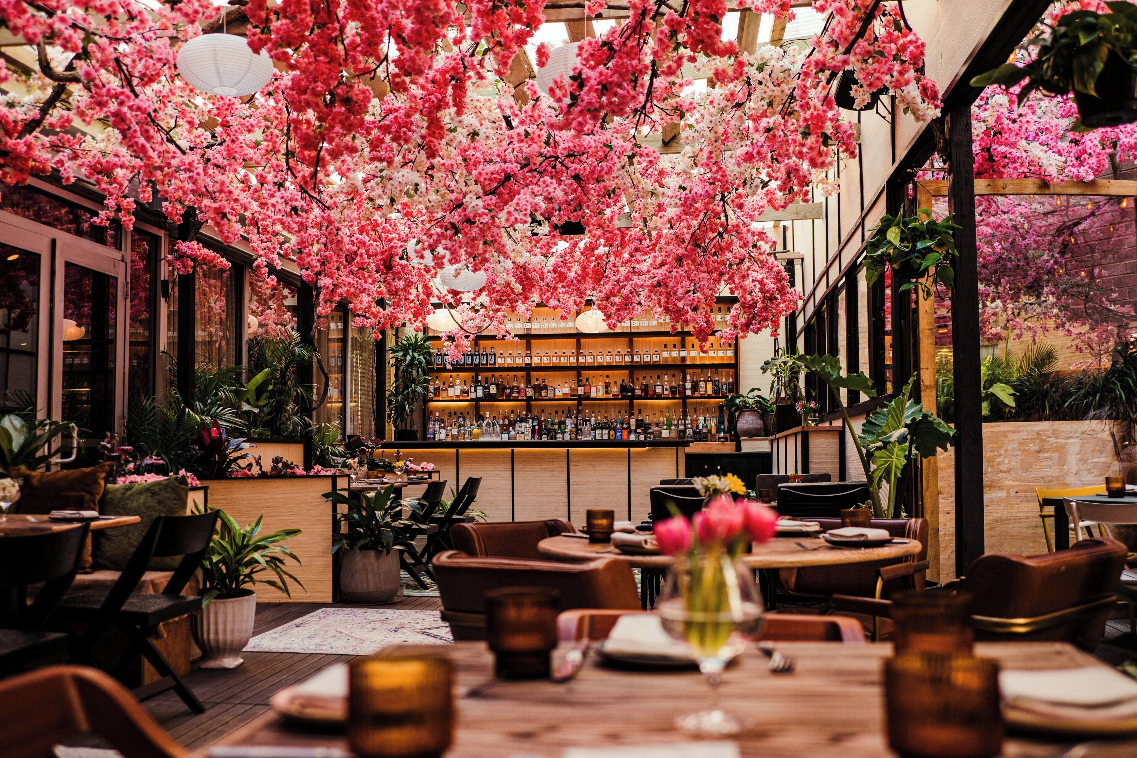 Un espace intérieur aménagé avec des tables, des chaises et un coin bar.