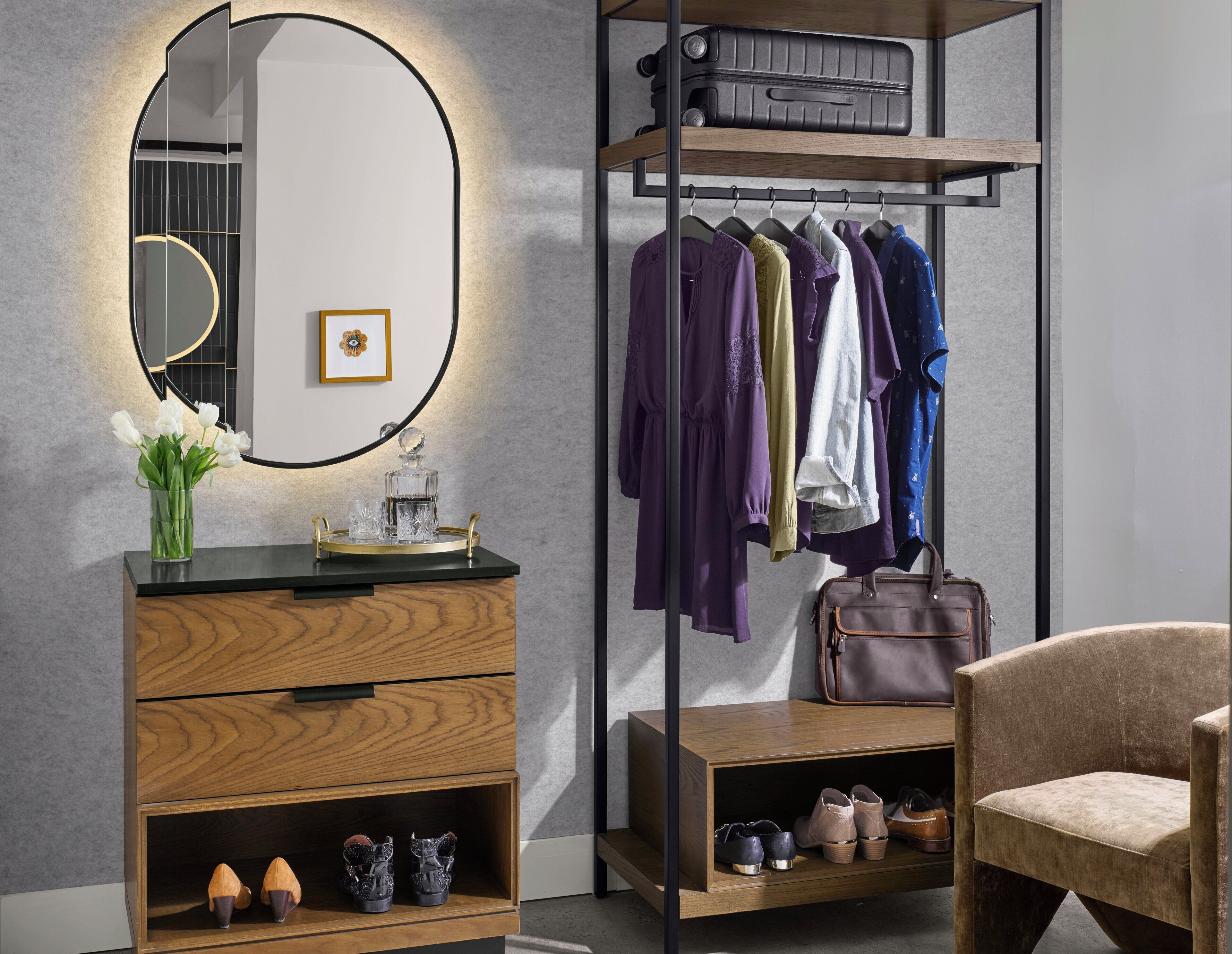 A modern room with a vanity, mirror, and clothing rack.