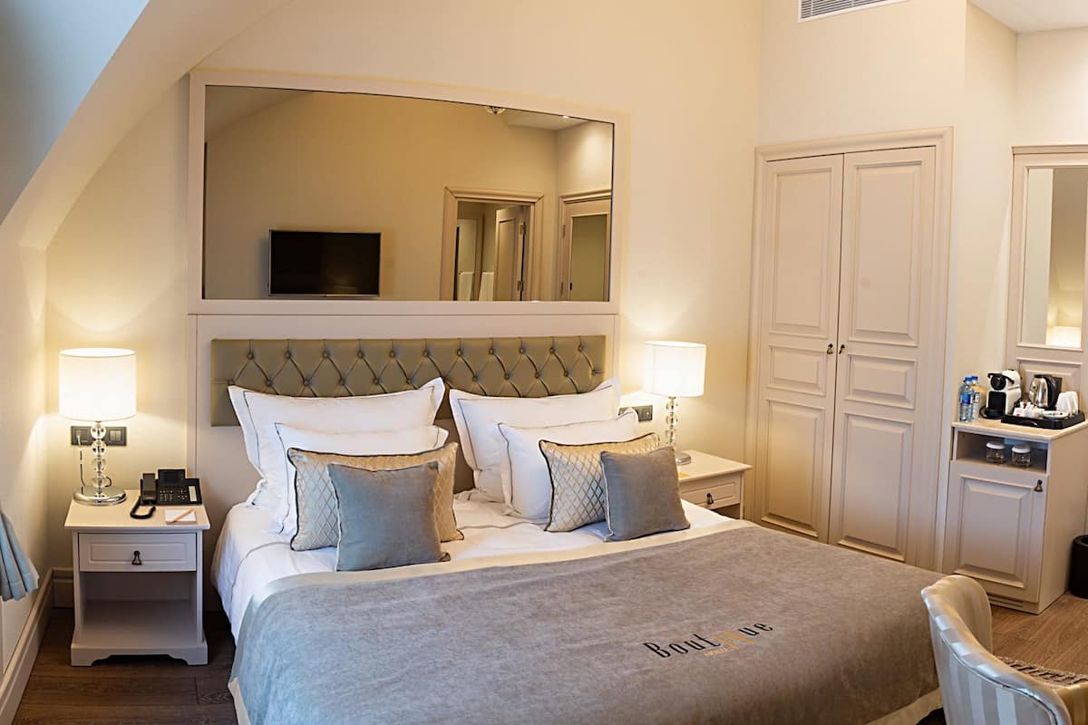 A hotel room with a large bed, a television, a wardrobe, and a bathroom.