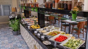 Un bufé con diferentes opciones de comida y piso de baldosas.