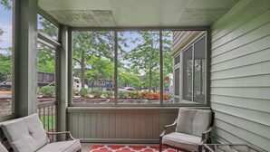 A covered porch with two chairs and a patterned rug. - Pointes North Inn 109 | Downtown Charlevoix | Indoor pool (Charlevoix)