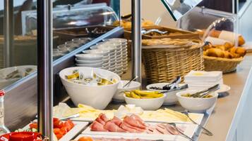 A buffet with various food items including fruits, cheeses, and meats.