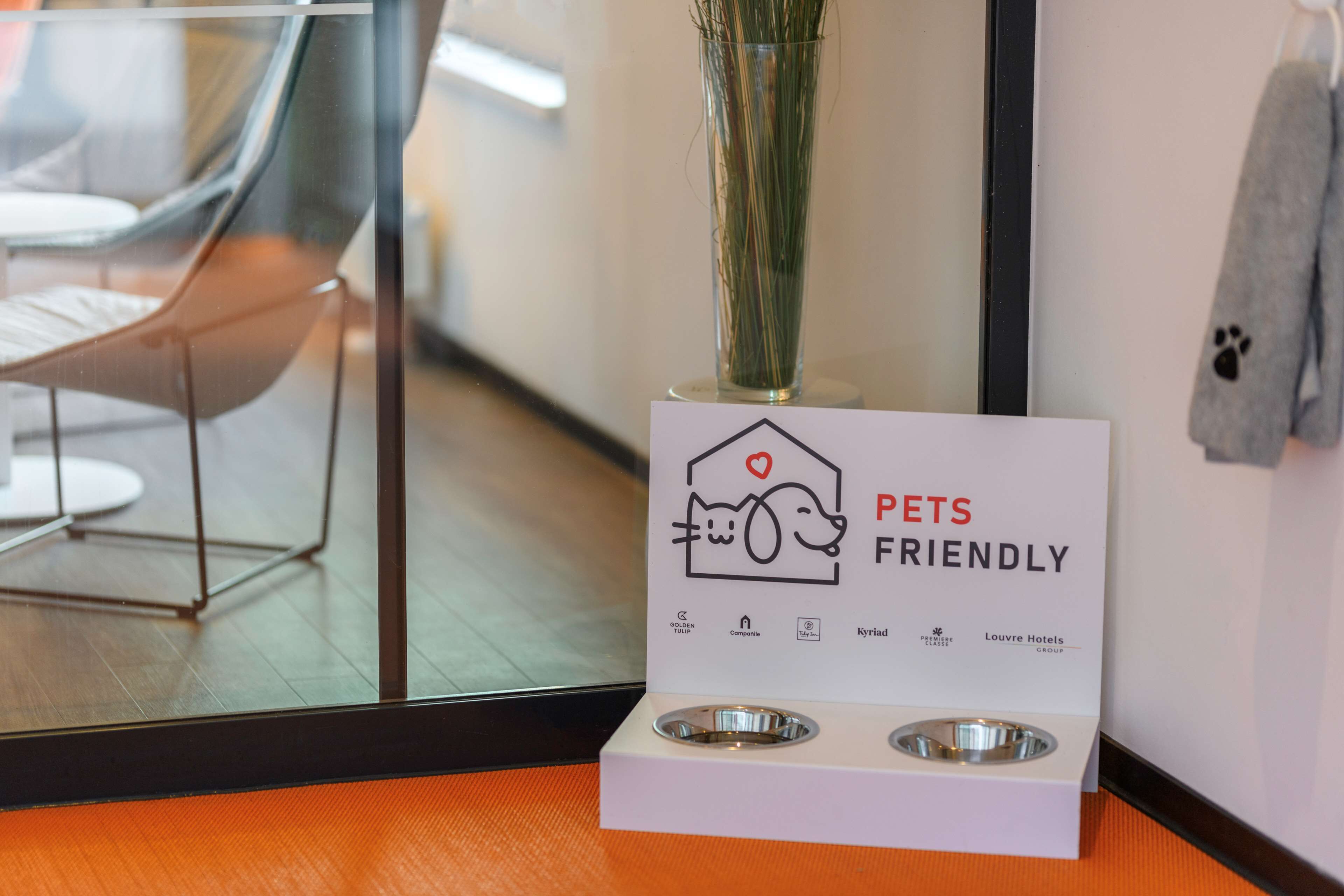 A sign indicating the hotel is pet-friendly, with a dog and cat icon, and logos of associated brands.