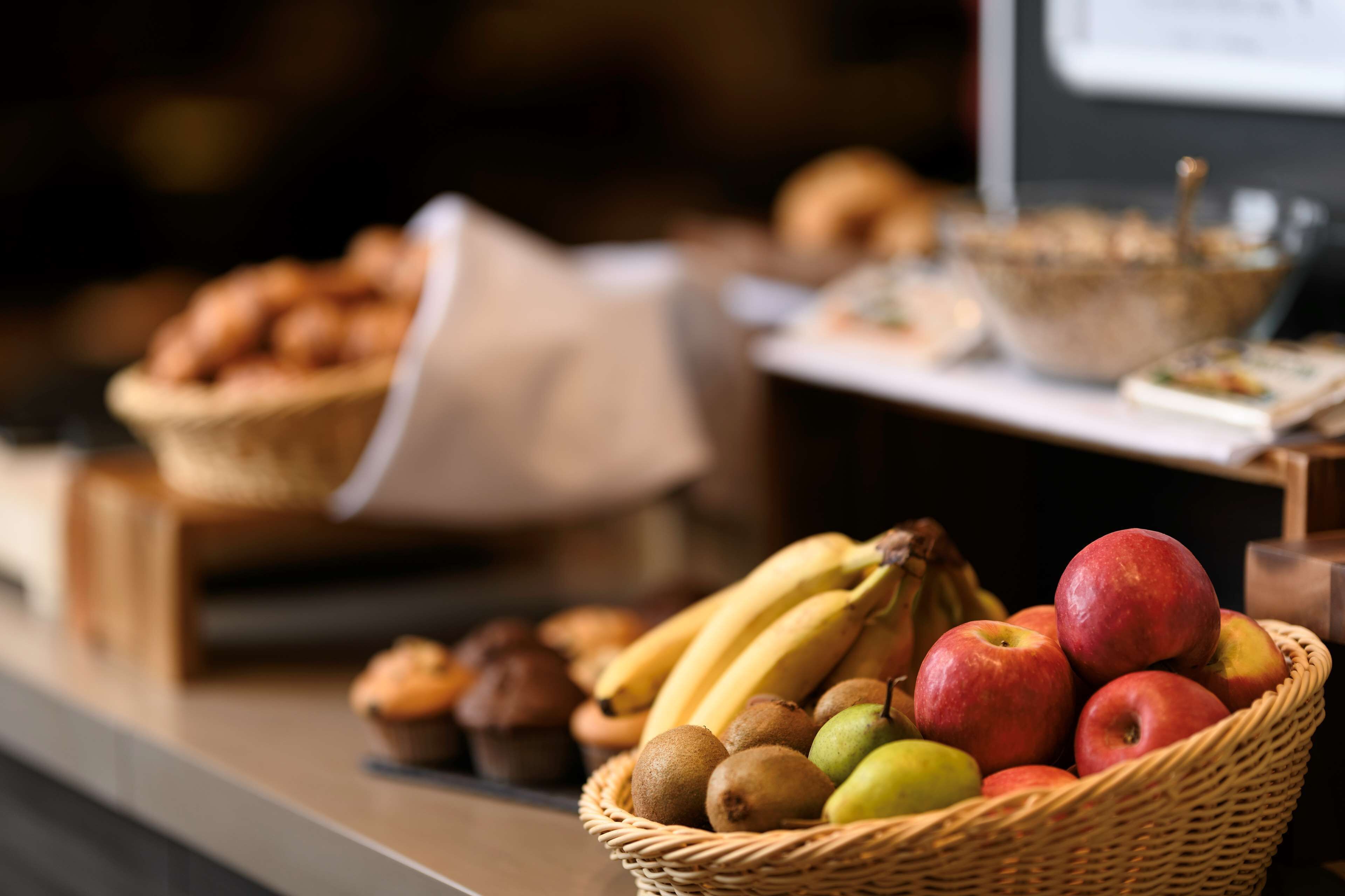 Una cesta de frutas y pasteles sobre una encimera.