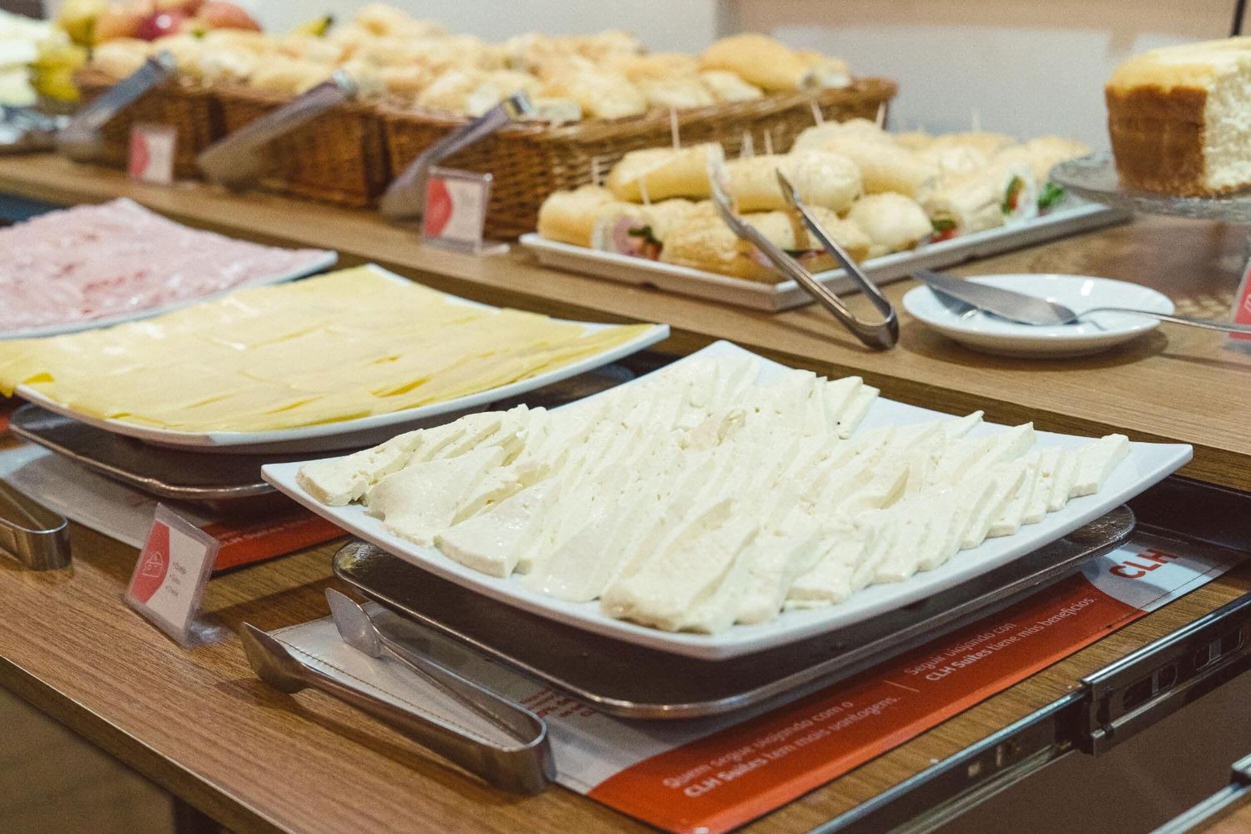 Ein Buffet mit verschiedenen Speisen, darunter Aufschnitt, Käse und Gebäck.