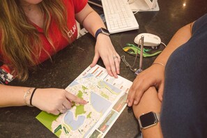 Deux personnes sont penchées sur une carte détaillée, posée sur une table avec un clavier et une souris.