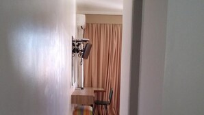 A narrow hallway with a tiled floor leading to a dining area with a table and chairs. - Hotel Ipanema Inn (São Paulo)