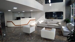 A modern lobby with a reception desk, seating area, and a staircase. - Hotel Ipanema Inn (São Paulo)