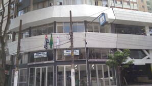 A hotel with multiple floors, large glass windows, and flags. - Hotel Ipanema Inn (São Paulo)