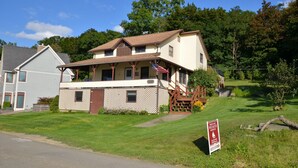 A two-story house with a porch and a small garden.