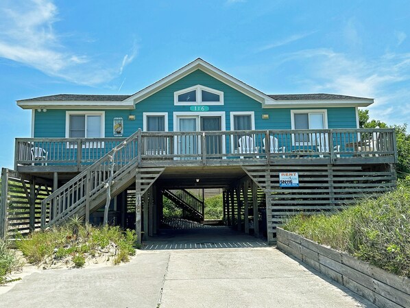 A two-story house with a covered walkway leading to the entrance.