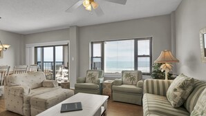A living room with a sofa, armchairs, a coffee table, and a ceiling fan. - DR 1405 - Beautiful oceanfront condo with tennis, pool and easy beach access (Wrightsville Beach)