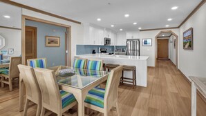 A modern kitchen with white cabinets, stainless steel appliances, and a central island. - Wrightsville Dunes F-2B - Oceanfront condo with community pool, tennis, beach (Wrightsville Beach)