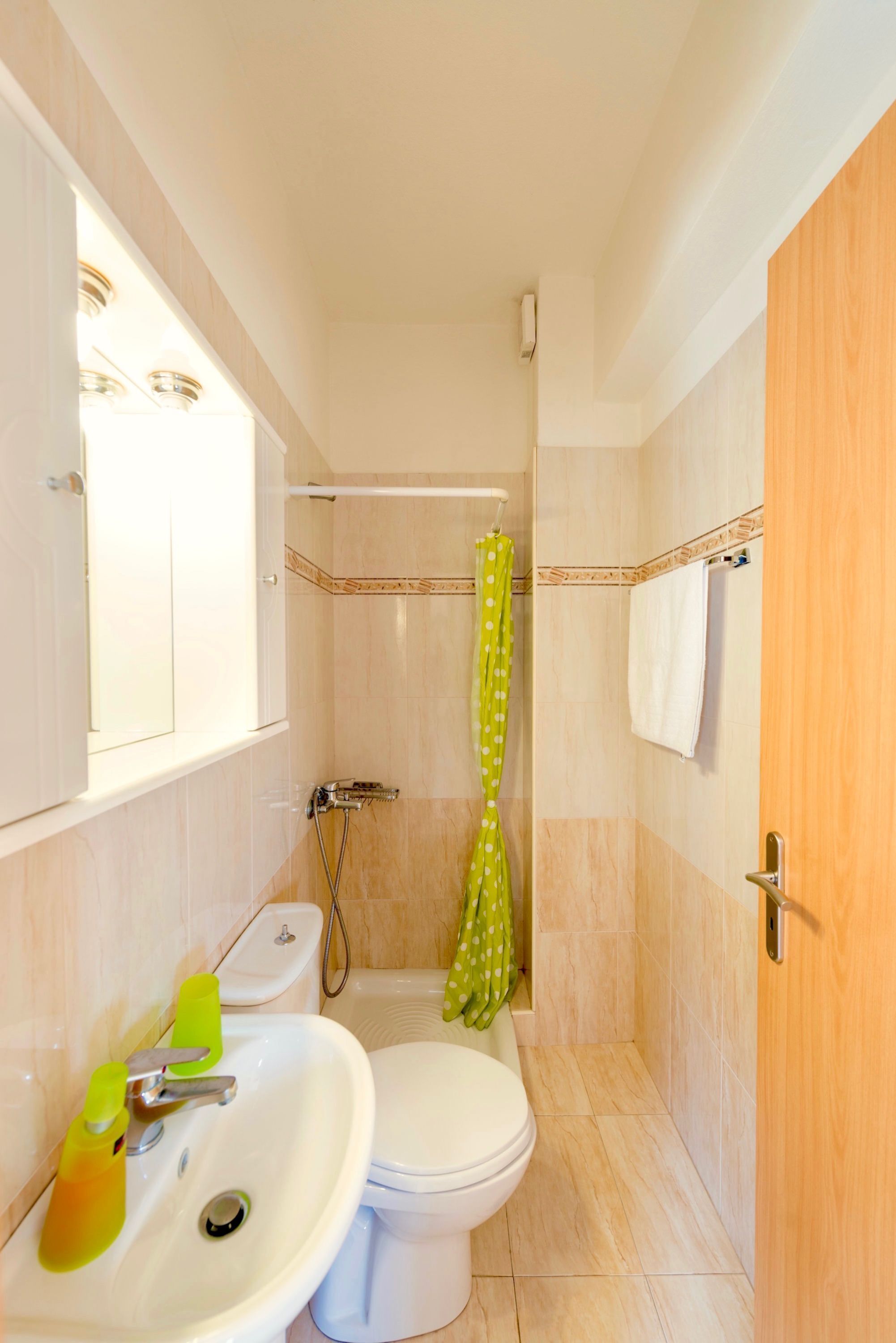 A small bathroom with a toilet, sink, and shower.