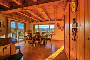 A wooden dining room with a table and chairs, a view through large windows, and a wooden ceiling. - 'Bearpen Lodge' on 125 Acres - Near Belleayre Mtn! (Halcott)