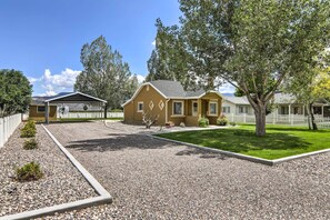 Et boligområde med et hus, en overdækket terrasse og en velplejet græsplæne.